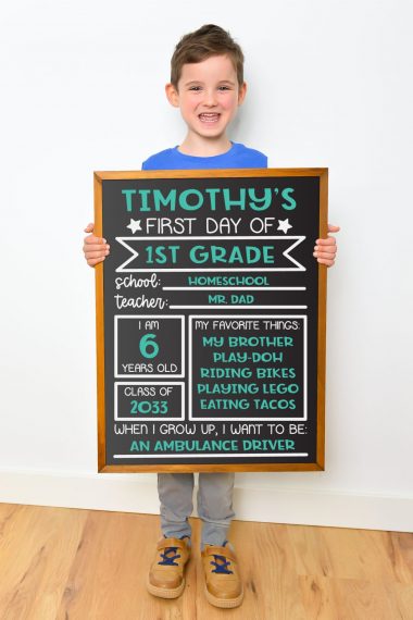 Young boy holding chalkboard sign against white background