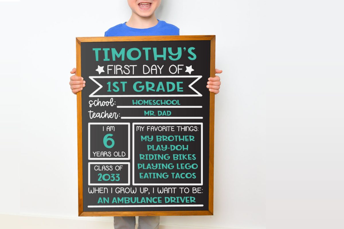 Young boy holding chalkboard sign against white background