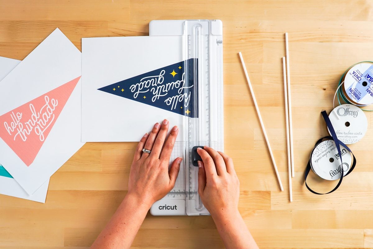 Hands using paper trimmer to cut flags.