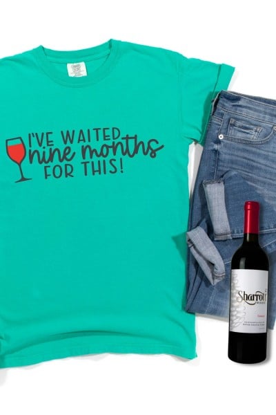 Free wine SVG on teal shirt with wine bottle and jeans