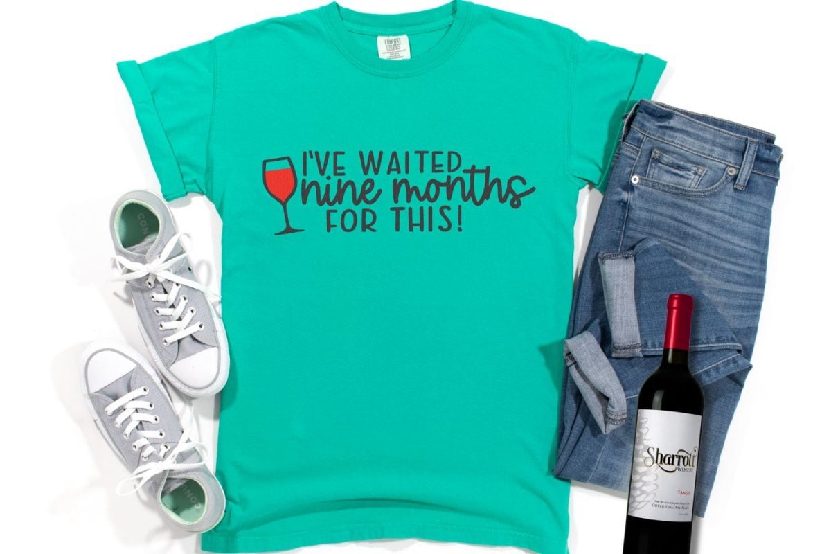 Free wine SVG on teal shirt with wine bottle and jeans