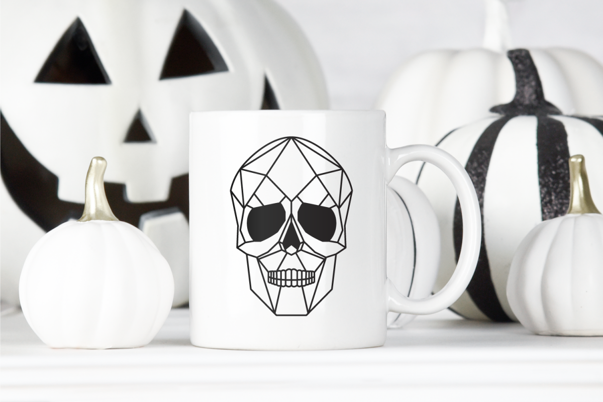 Black geometric skull on white mug with black and white Halloween decorations