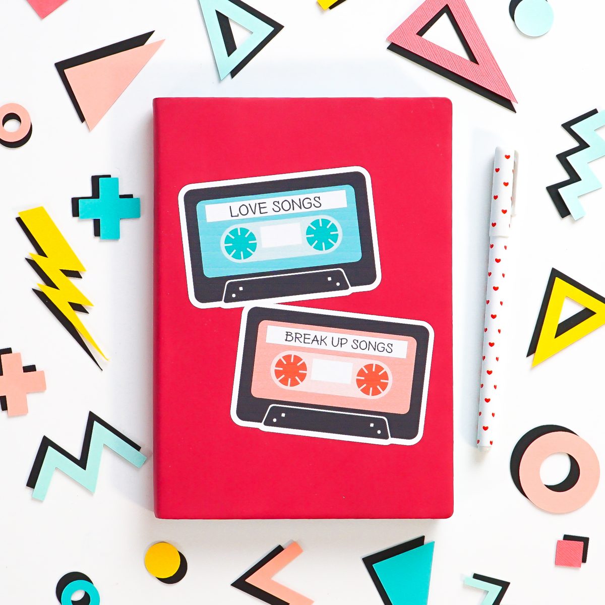 Pink notebook with big mix tape sticker, surrounded by 80's shapes