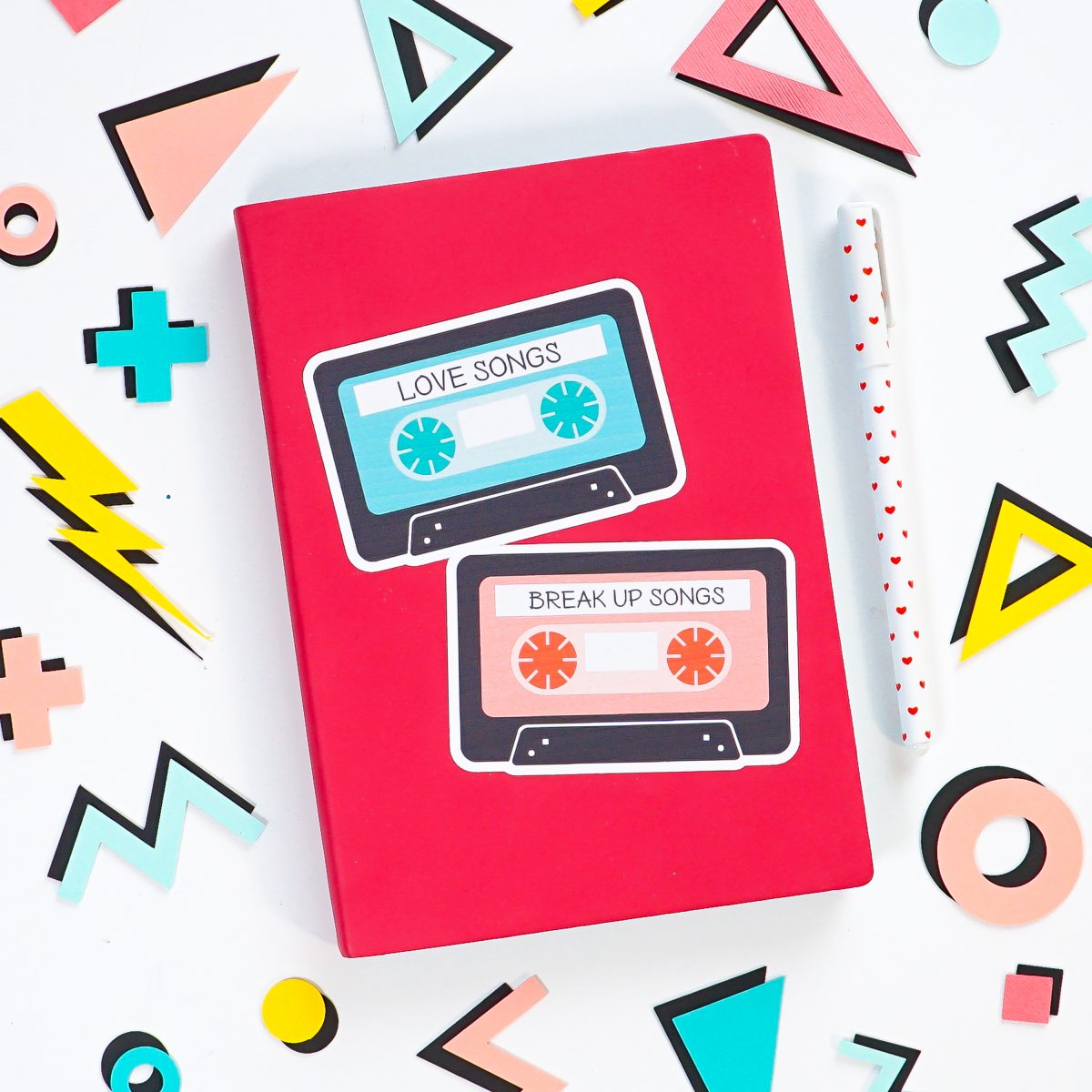 Pink notebook with big mix tape sticker, surrounded by 80's shapes