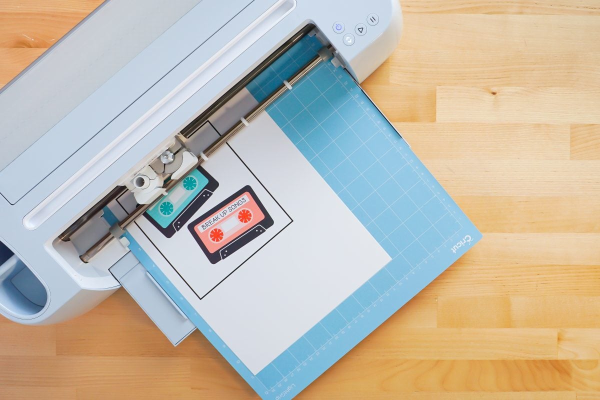 Overhead shot of Cricut Maker 3 with blue mat and printed mix tapes loaded.