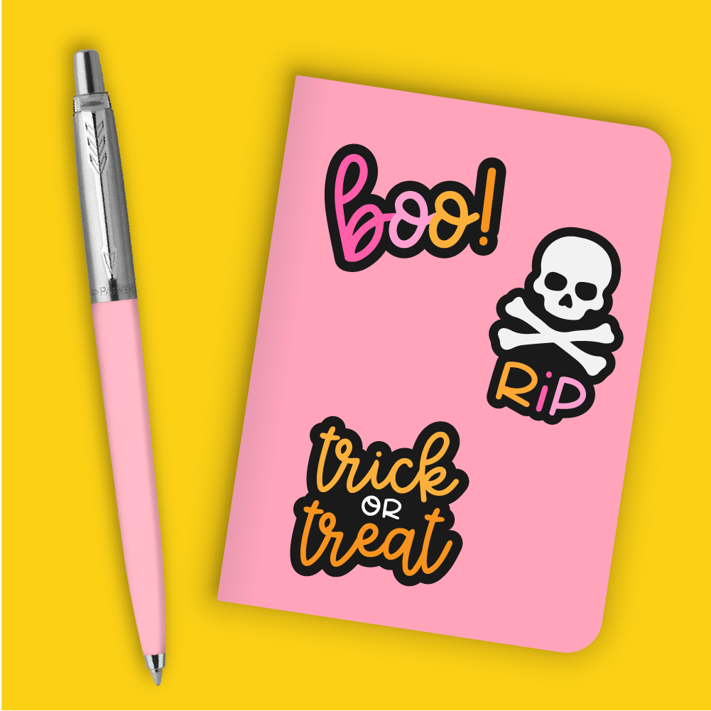 Pink notebook with Halloween stickers on yellow background.