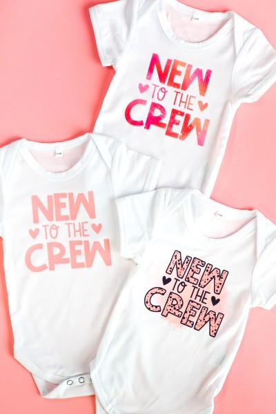 Three onesies with "new to the crew": sublimation, infusible ink, htv