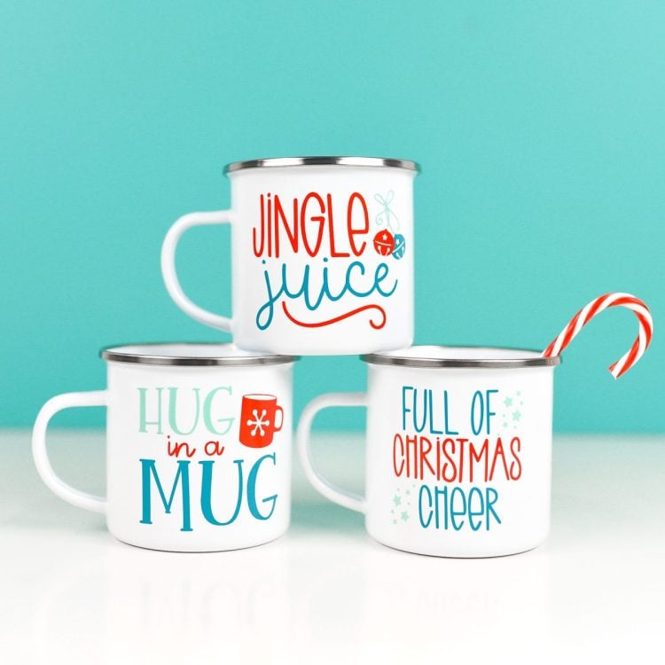 Final DIY Christmas mugs with blue background and candy cane.
