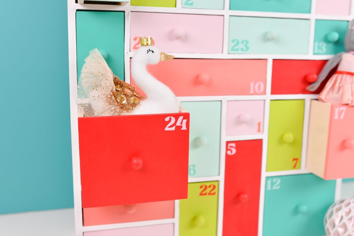 Closeup of painted wooden advent calendar with swan ornament