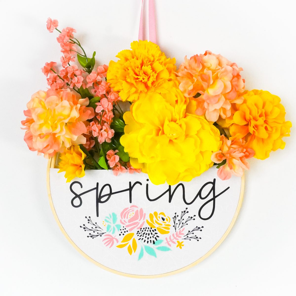 Spring embroidery hoop wreath hanging on a wall