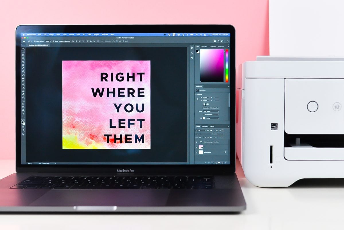 Open laptop showing Photoshop next to printer