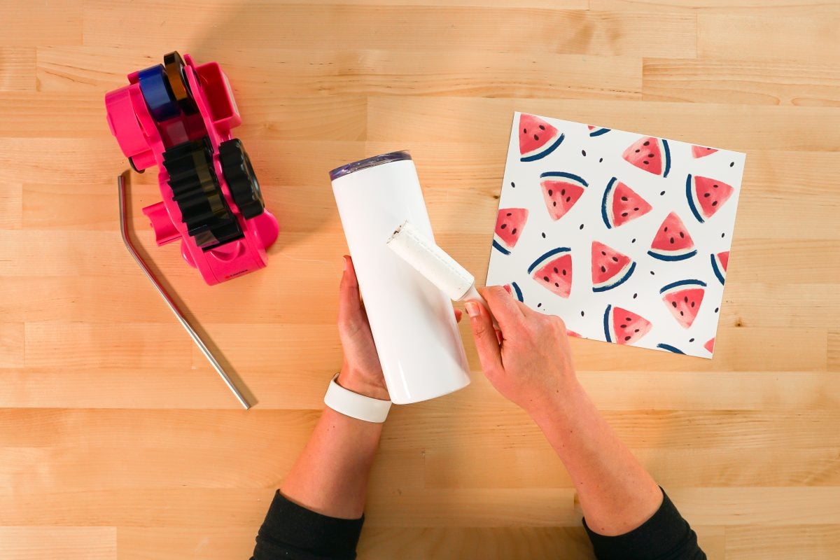 Overhead shot of hands lint rolling tumbler.