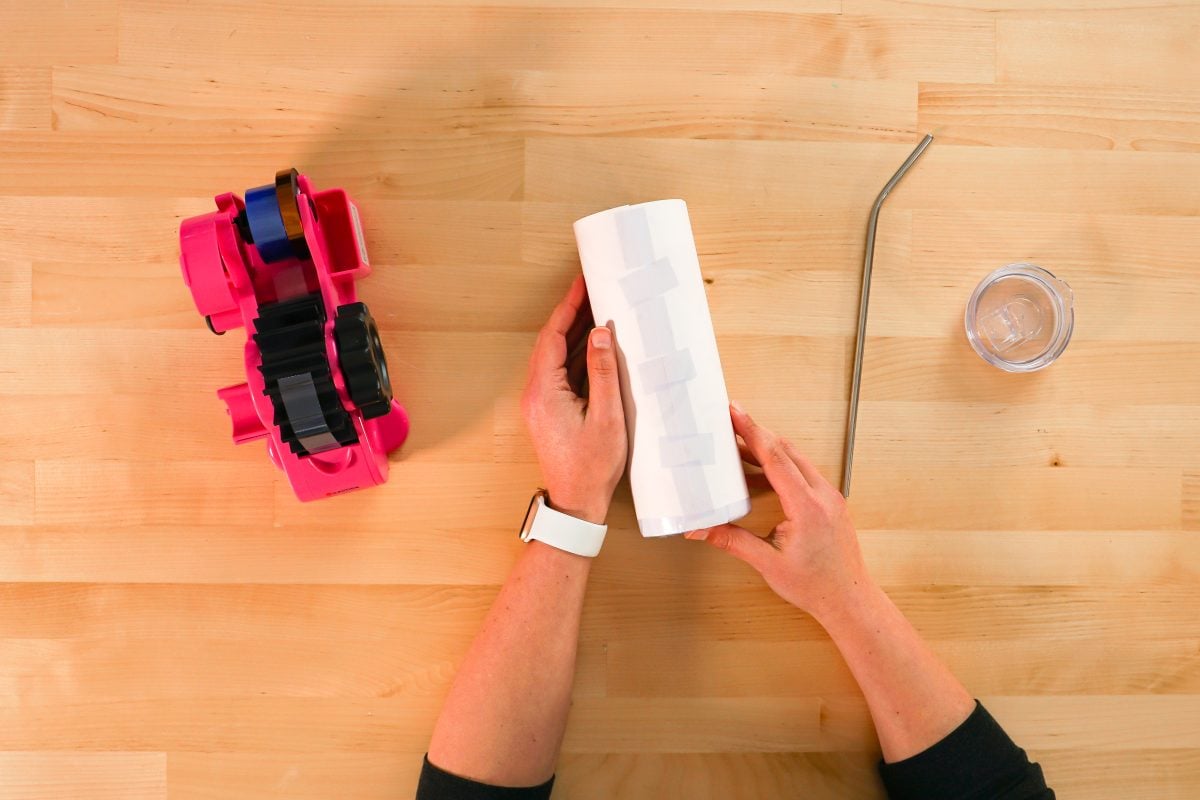 Overhead shot of hands taping tumbler.