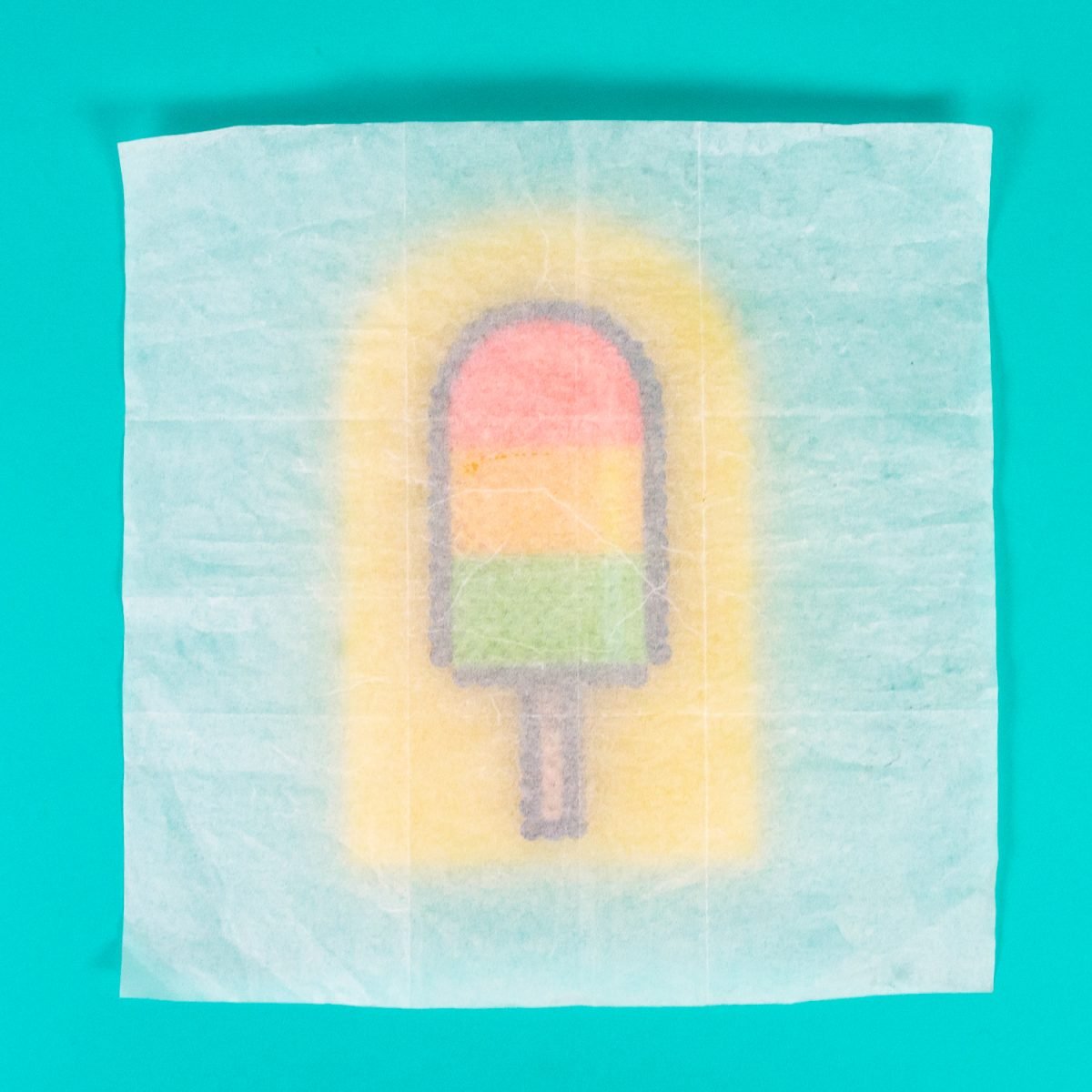 Parchment paper covering a Perler Bead popsicle design