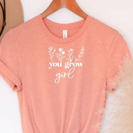 Peach colored shirt with wildflowers on it and the saying You Grow Girl