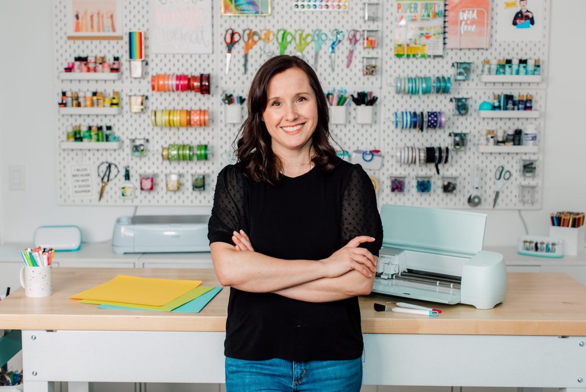 Cori George standing in front of Gladiator workbench with Cricut on top.