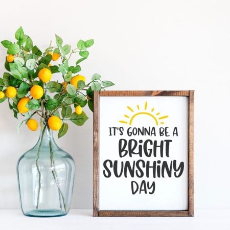 Framed white sign with the sun on it and the words It's Going to be A Bright Sunshiny Day