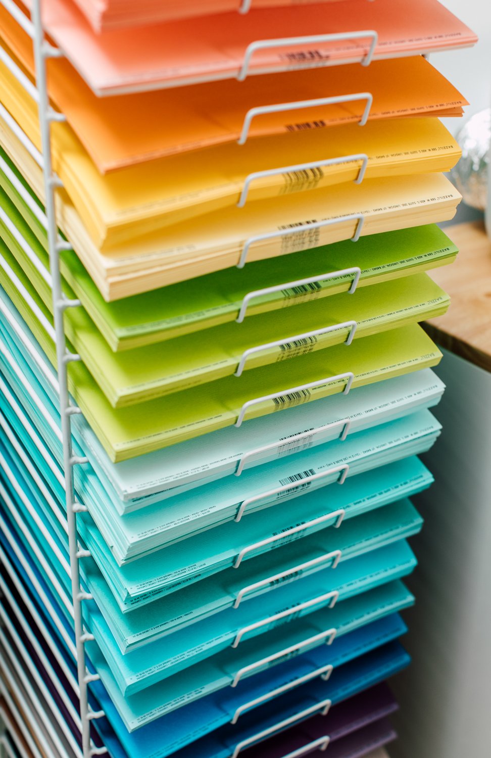 Wire rack with a rainbow of colored paper.