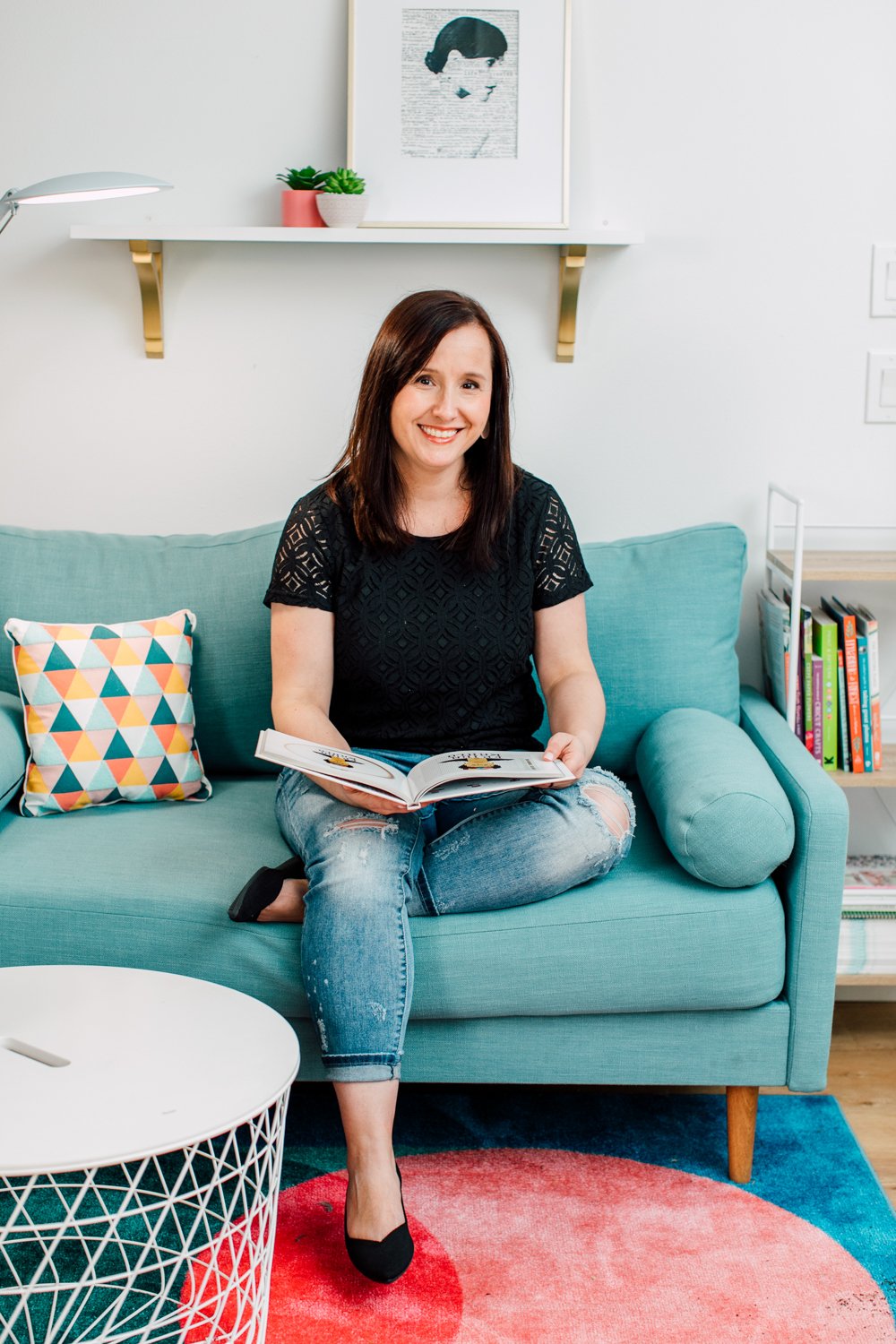 Craft room tour: Cori sitting on blue couch with a book open in her lap