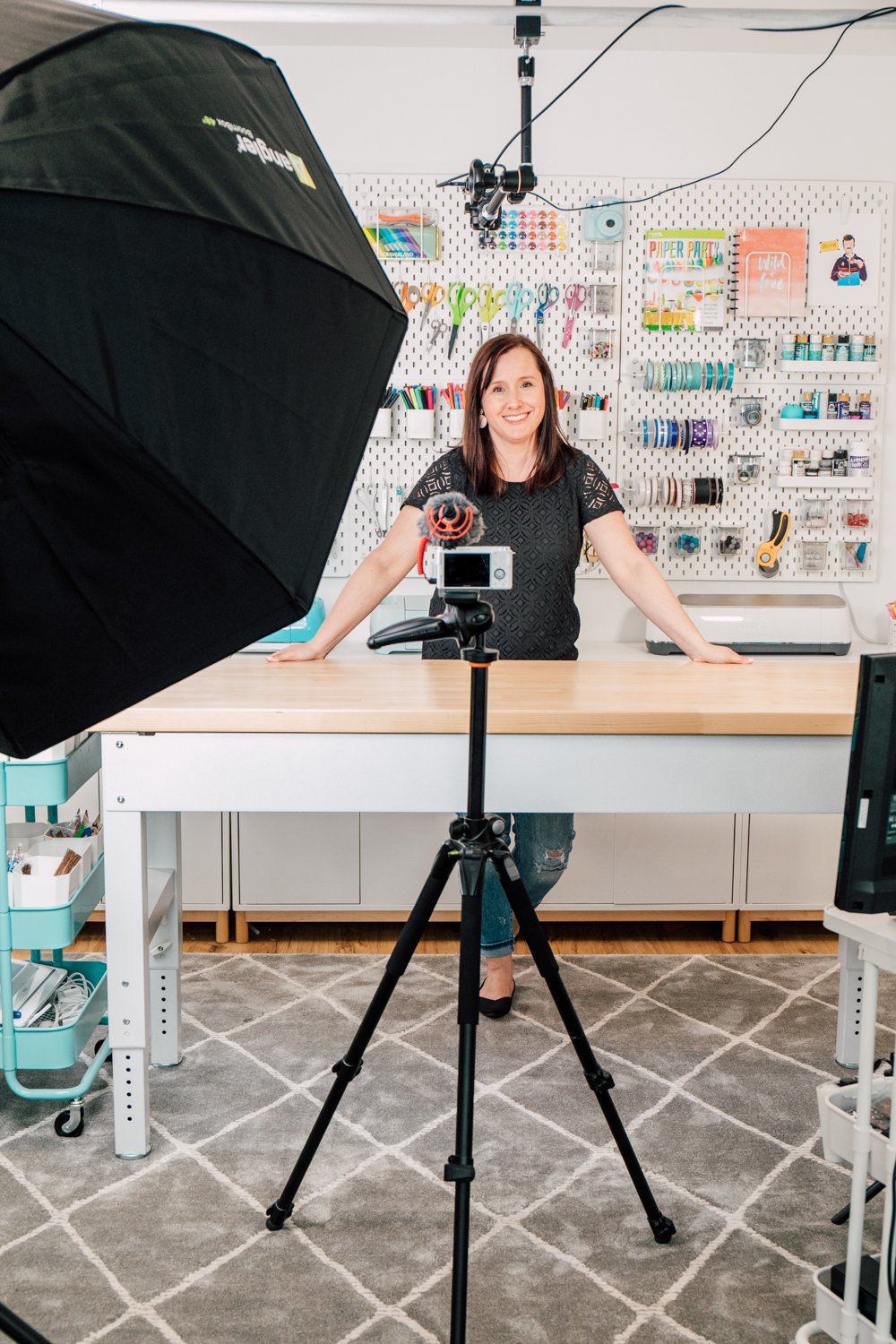 Cori at desk surrounded by camera equipment
