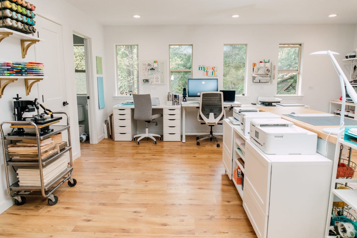 Craft room tour: Larger view of room facing windows with desk and Cricut