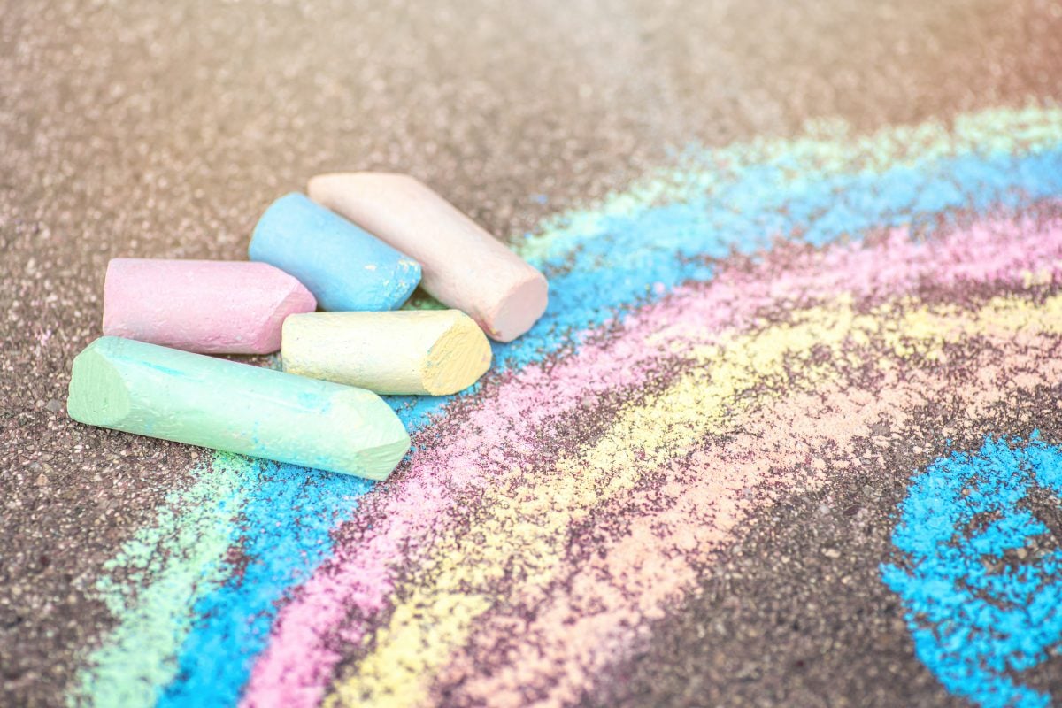 Sidewalk chalk with rainbow drawing.