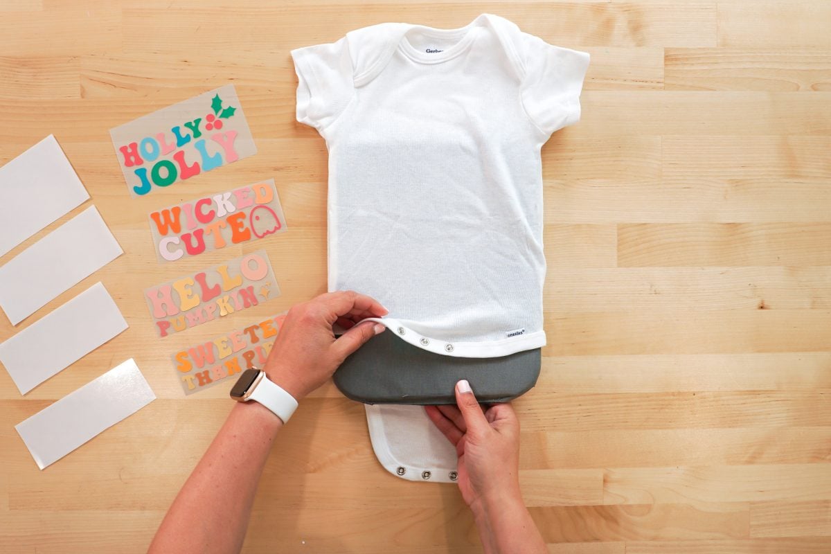 Hands putting pressing pillow inside onesie.