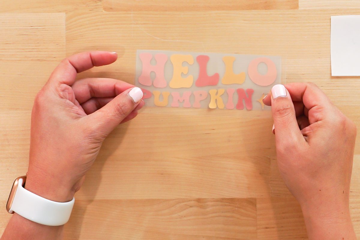 Hands applying the mask to the Hello Pumpkin image.