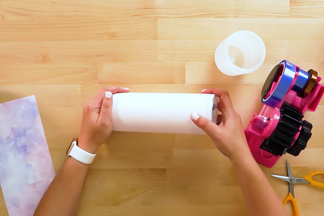 Hand showing how to roll the edge of the tumbler into the table.