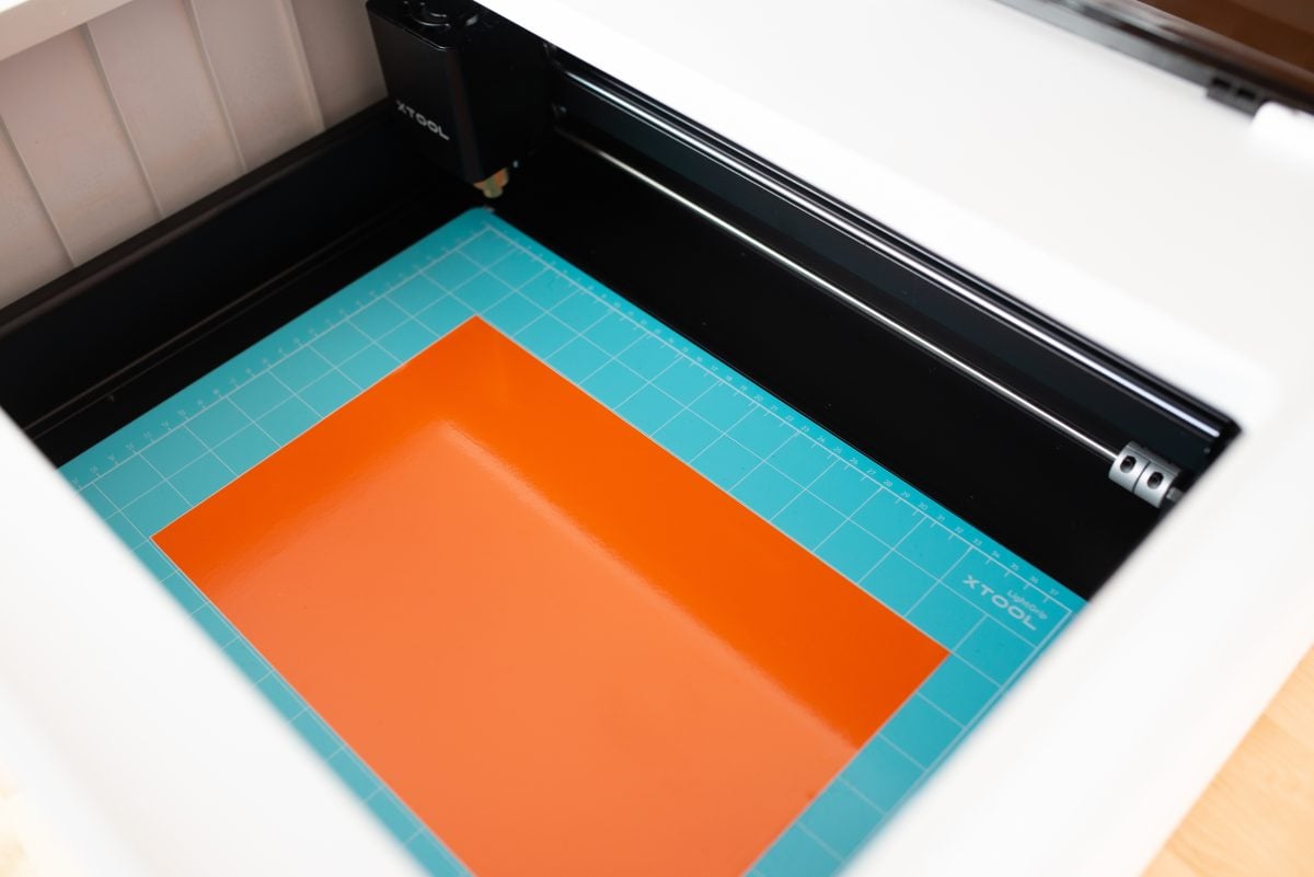 M1 with blue cutting mat and orange vinyl inside the bed of the machine.