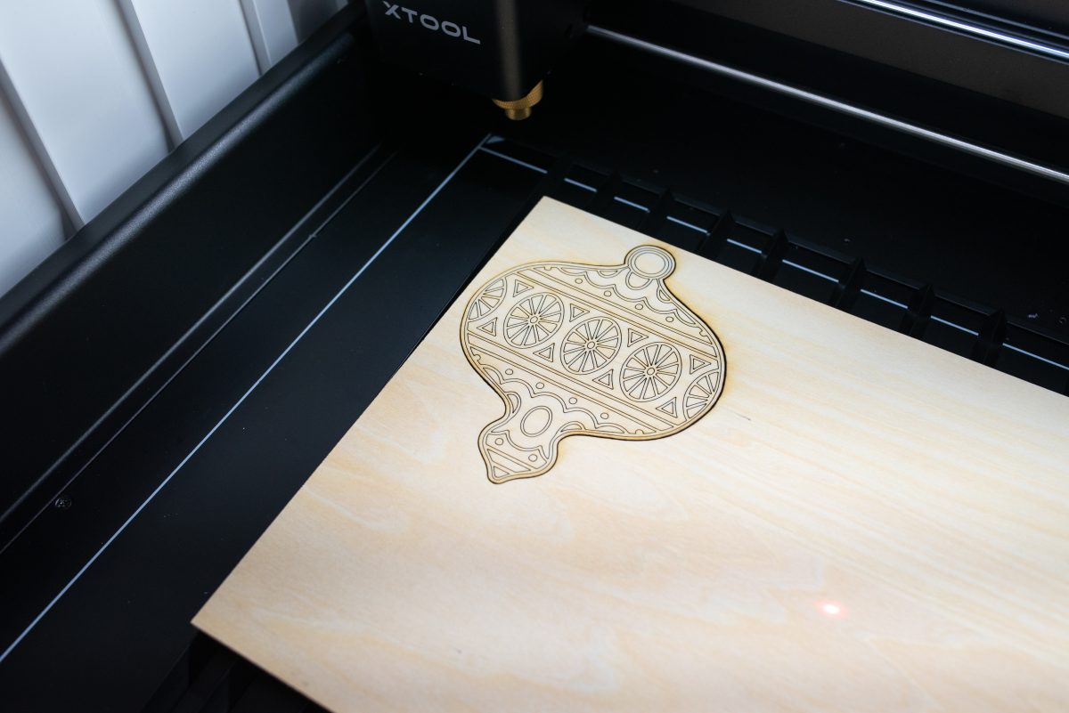 Laser cut ornament still in the bed of the laser.