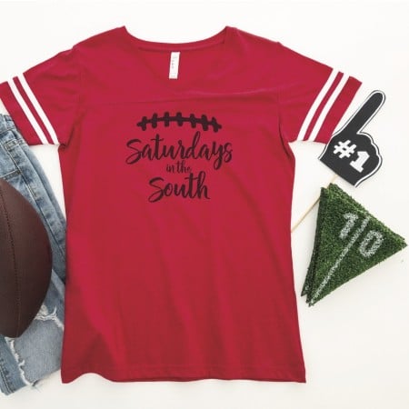 Red football jersey with a football image on it and the words Saturdays in the South