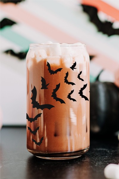 Glass cup with iced coffee, and flying bats decal.