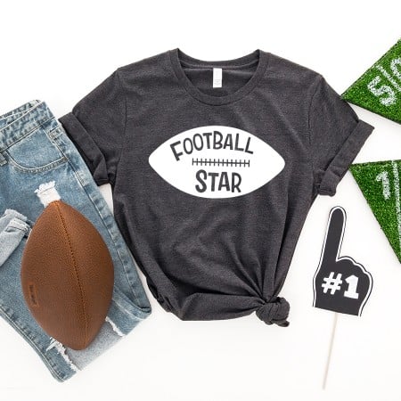 Dark gray t-shirt with the shape of a football on it and the words Football Star