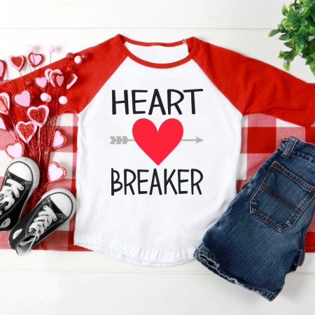 Red and white baseball style shirt decorated with a red heart with an arrow through it and the words Heart Breaker