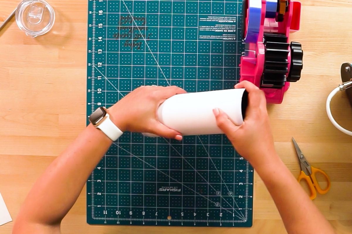 Hands rolling the edges of the tumbler on the desk