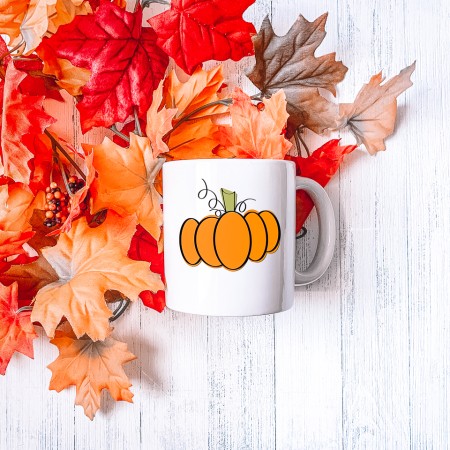 White mug with a hand drawn pumpkin on it