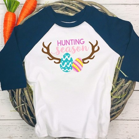 Black and white baseball shirt with Easter eggs on antlers with the saying Hunting Season