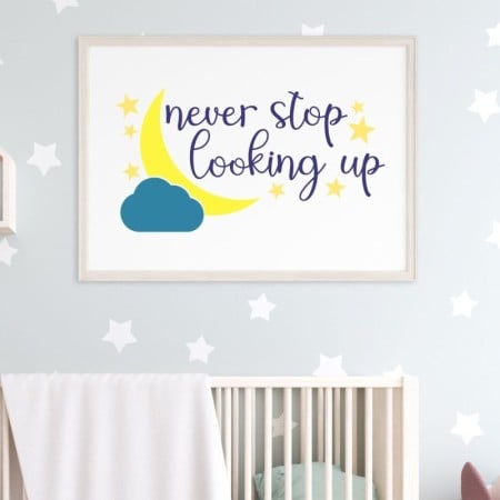 White framed sign with a moon, clouds and the words Never Stop Looking Up