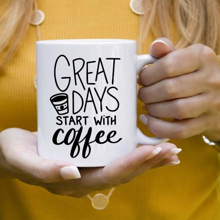Woman holding a white coffee mug that says Great Days Start with Coffee