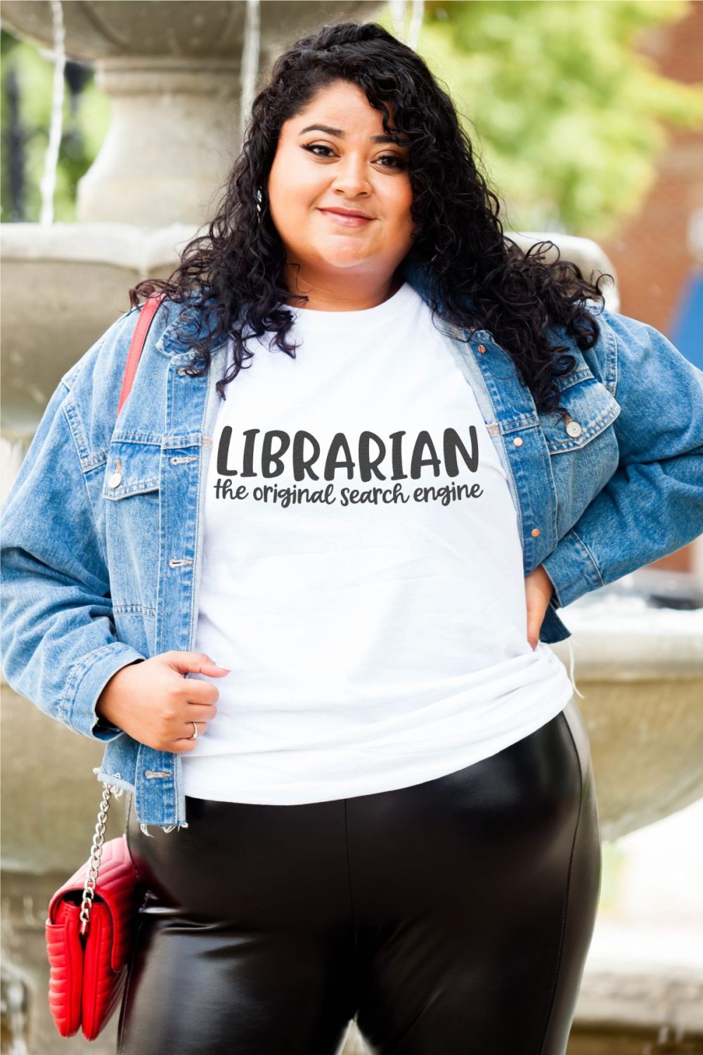 Latina plus size model with white shirt that says "librarian: the original search engine" and a jean jacket