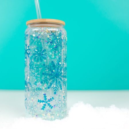 Final snowflake tumbler with faux snow and teal background.