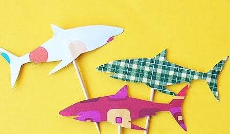 Image of three different colored cupcake toppers in the shape of a shark