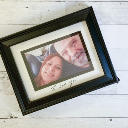 Picture in a black frame of a smiling couple