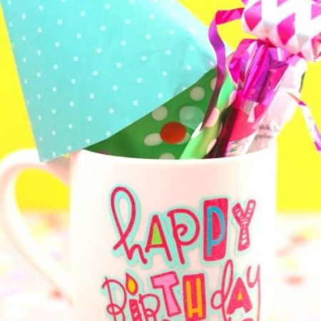 White mug with Happy Birthday design on it and filled with birthday goodies