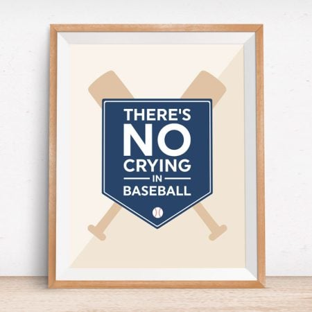 A framed picture of two baseball bats forming an X with a sign in the shape of a baseball base that says There's No Crying in Baseball