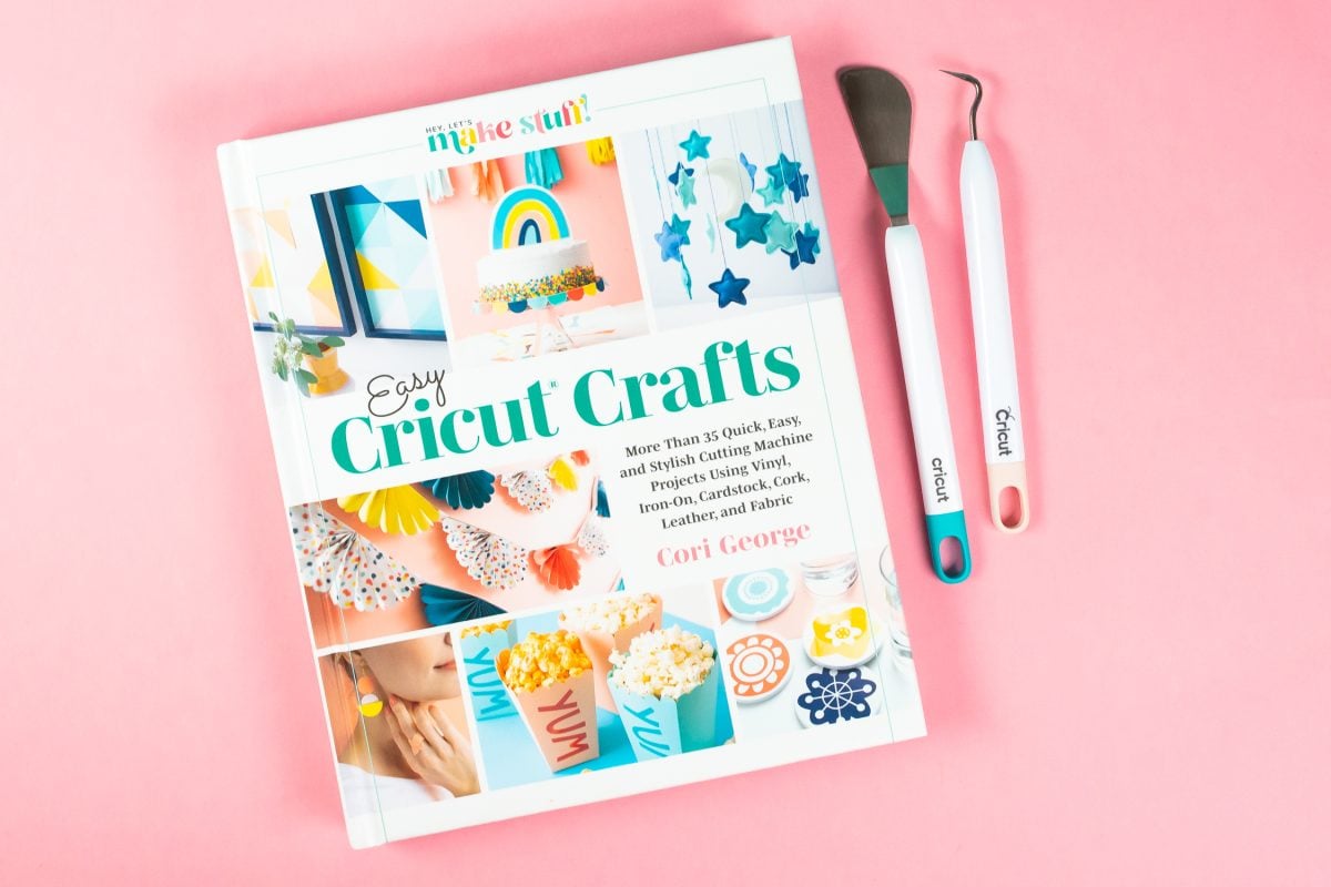 Easy Cricut Crafts Book on pink background with Cricut tools.