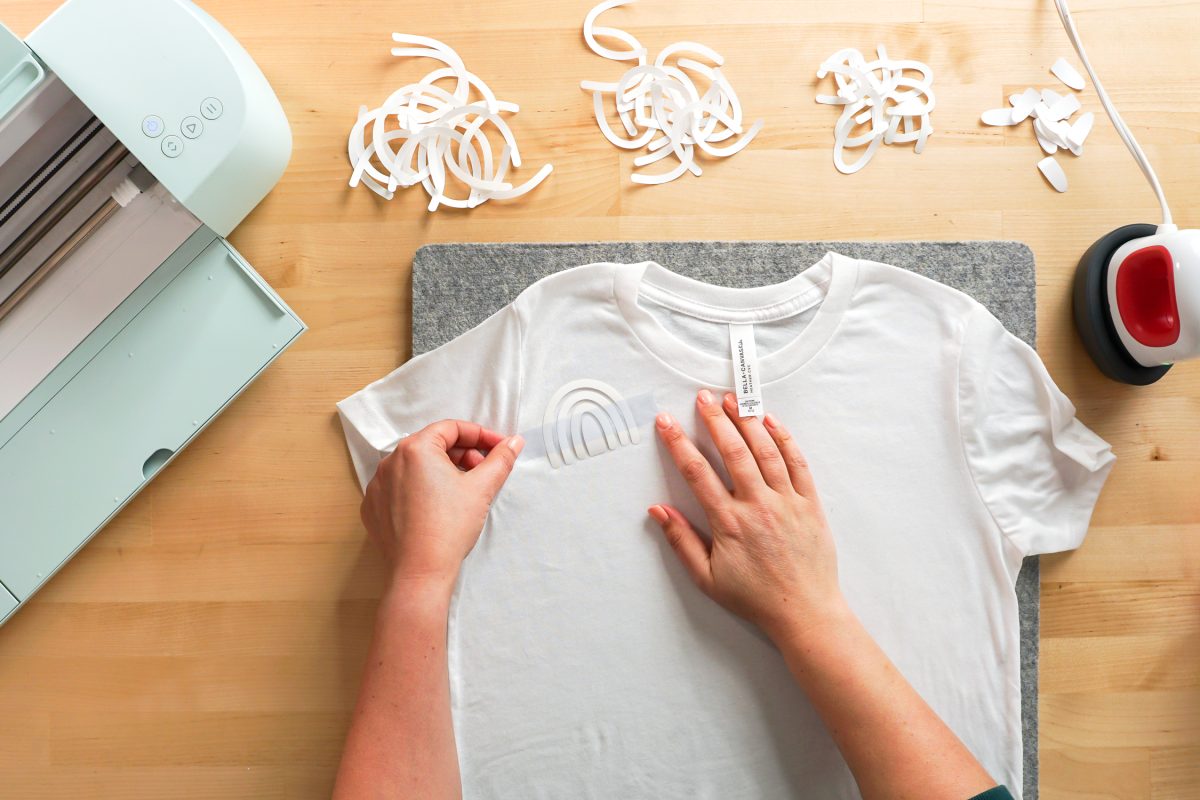 Overhead shot of hand placing a piece of heat resistant tape over the rainbow.