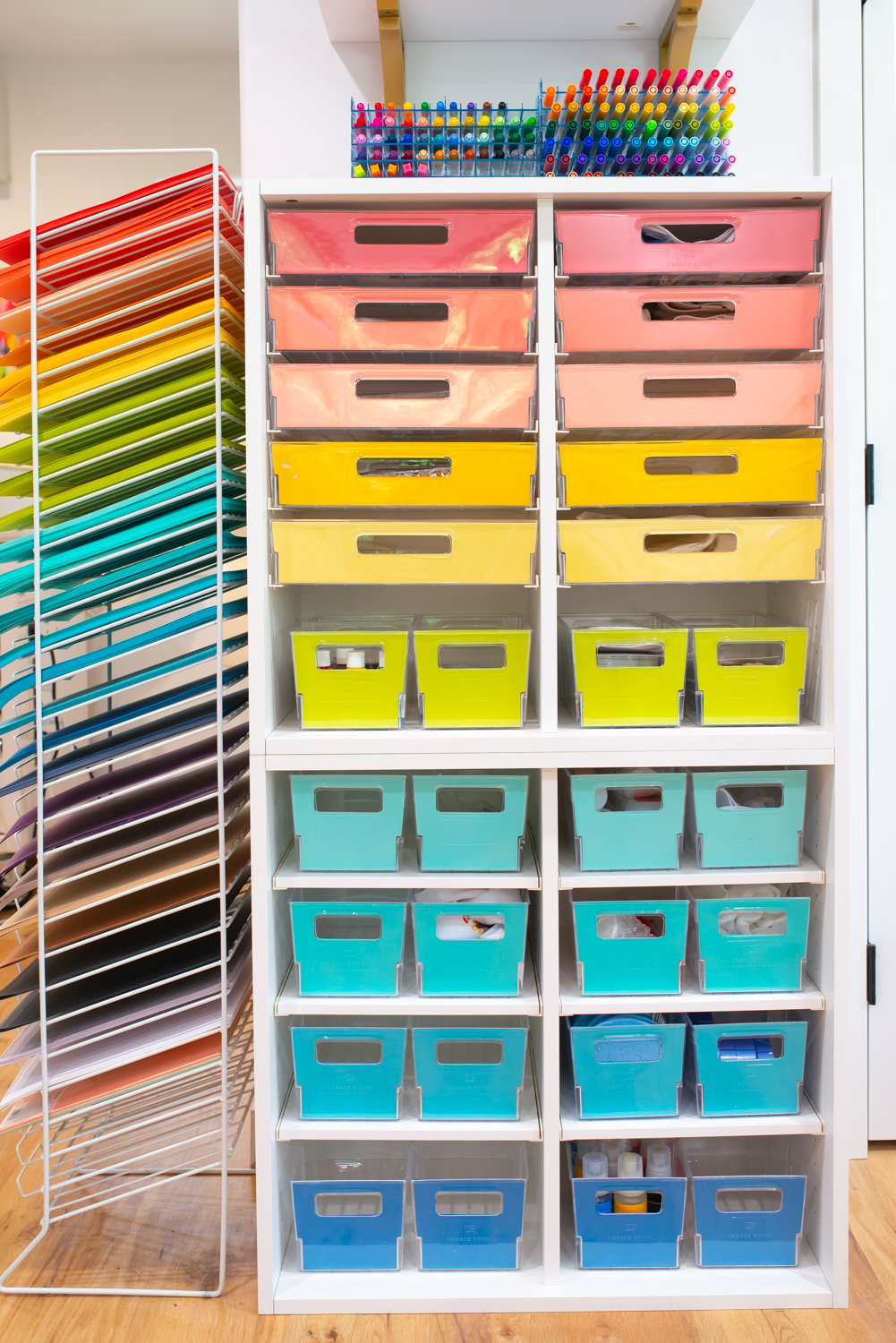 Side view of two Create Room Cubbies stacked on top of each other with drawer fronts organized in rainbow order, filled with supplies