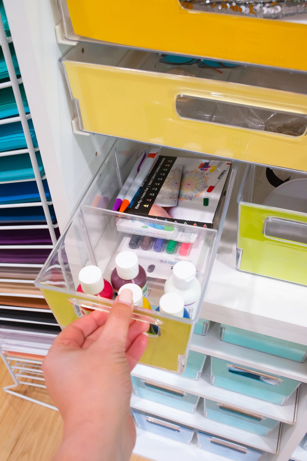 Hand pulling out medium drawer with sublimation pens and paints